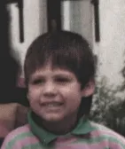 1987 — pixeliges Portrait eines dreijährigen Jungen mit verkniffenem Grinsen